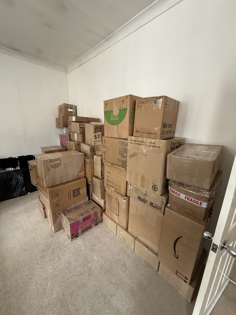 A room of packed and labelled moving boxes stacked ready for loading