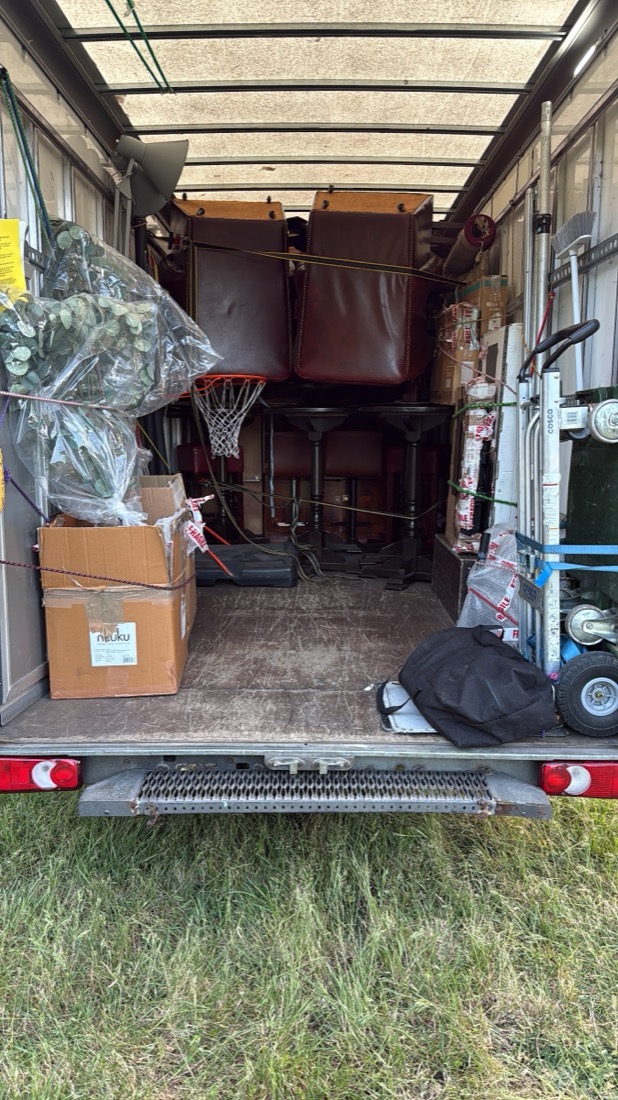 Pub furniture, padded benches and tables, loaded carefully for a business move